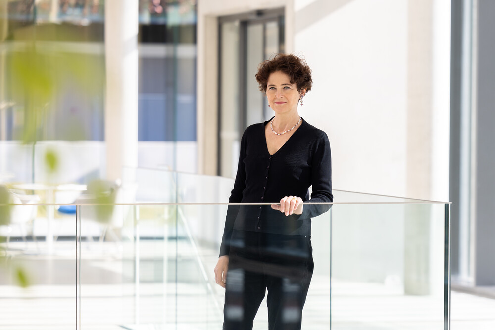 woman dressed in black stands at glass railing