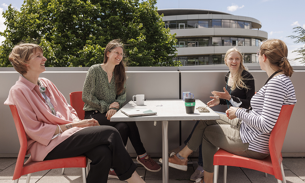 Four female scientists at table outside at EMBL