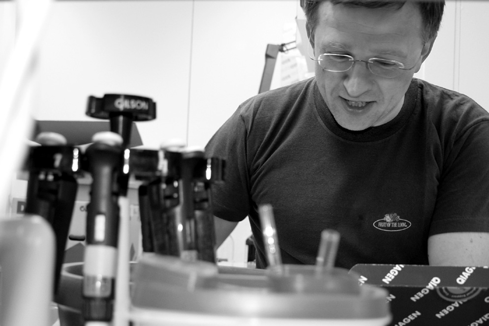 Male scientist looks at equipment in front of him.