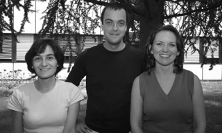 Two women and a man standing in front of a building