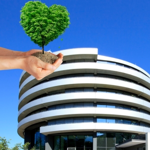 EMBL ATC building with hands holding out a small tree ready for planting