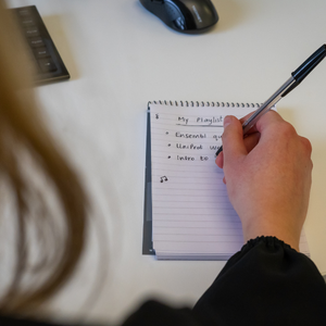 a white blond woman writes in a notepad