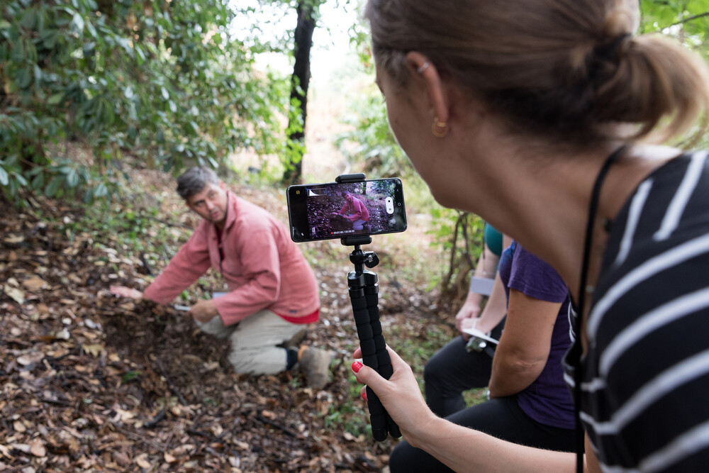 scientist collecting soil samples while being filmed