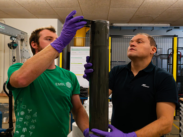 Two scientists inspecting a sediment core after it has been collected