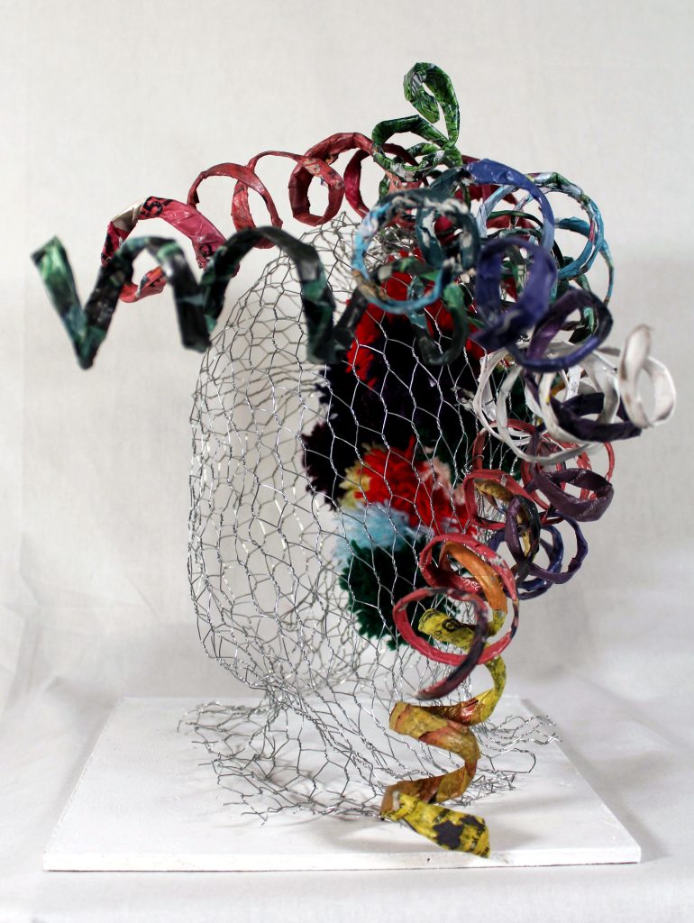 Wire mesh shaped into a 3D approximation of a human head, colourful spirals erupt form the the top right hand side of the 