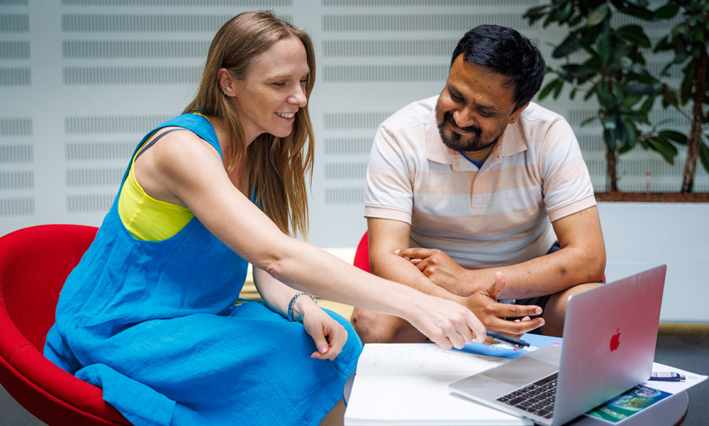 people discussing in front of a laptop