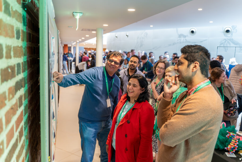 Staff laughing at a poster game at EMBL-EBI's 30th anniversary.