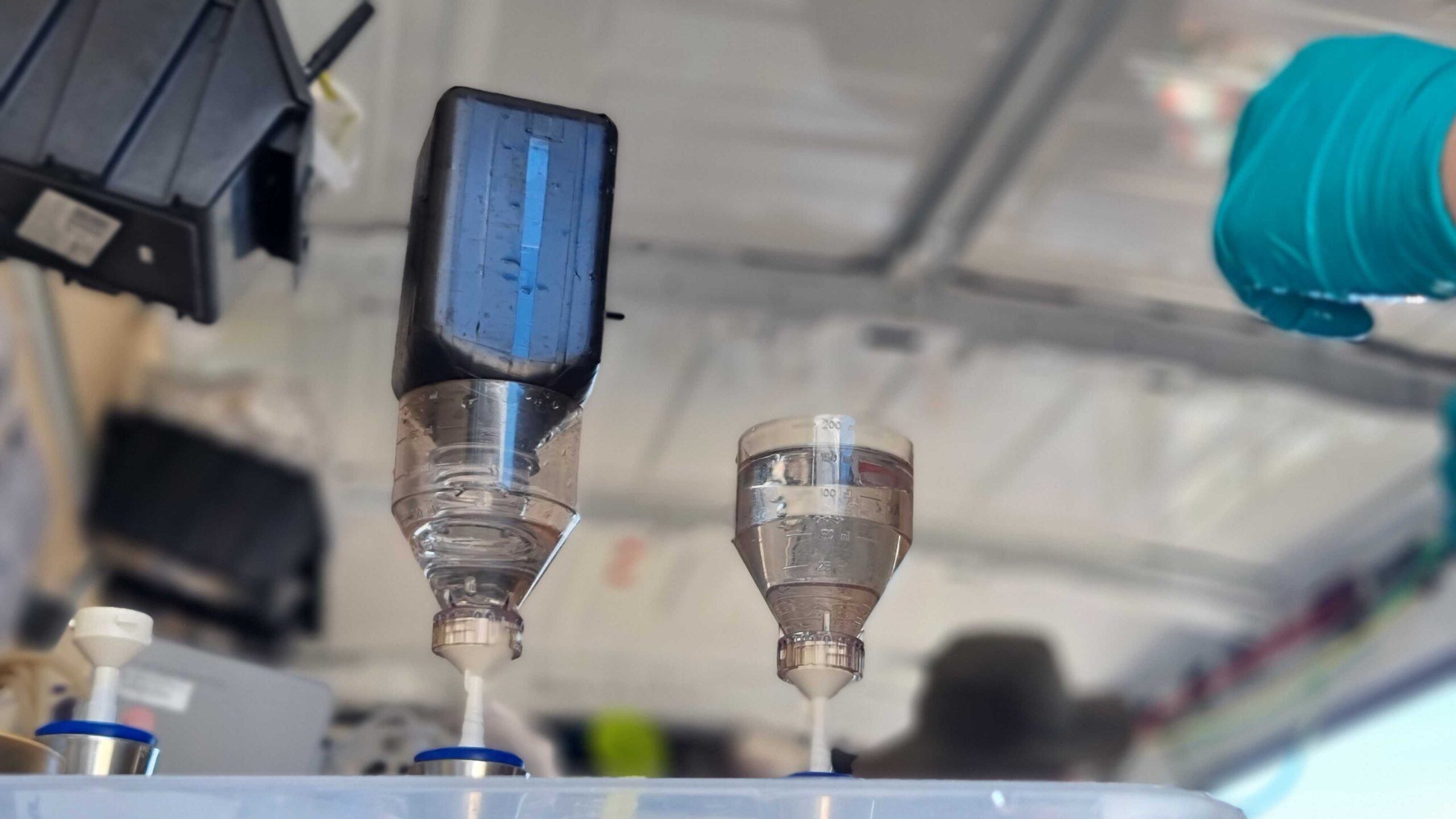 Another analysis deals with the pigments in the water. The bottle storing the sample for this has dark walls so that the pigments are not destroyed by light. Eine weitere Analyse befasst sich mit den Pigmenten im Wasser. Die Flasche, in der die Wasserprobe hierzu aufbewahrt wird, hat dunkle Wände, damit die Pigmente im Wasser nicht durch Licht zerstört werden.