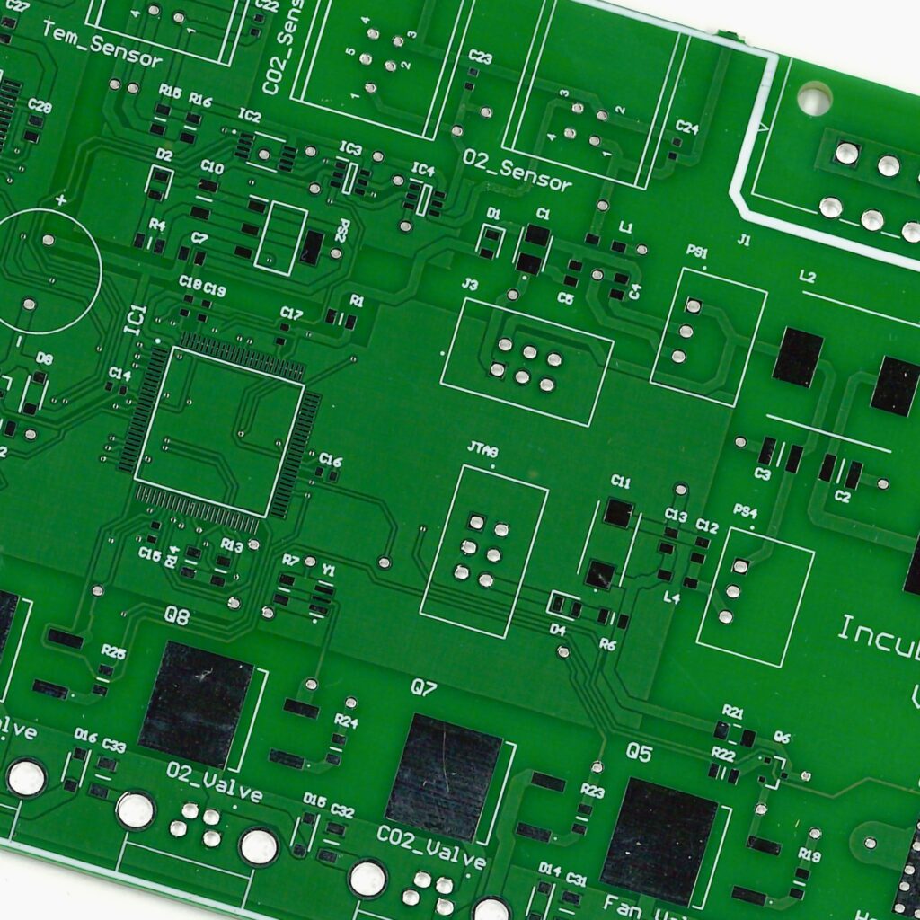 a green printed circuit board with various solder pads and traces visible