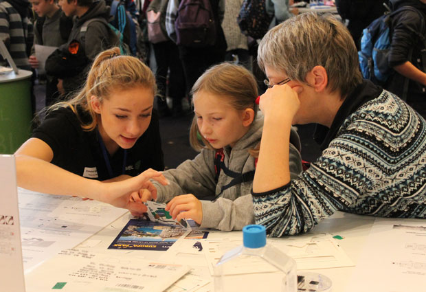 Visitors folding a microscope from paper. PHOTO: EMBL/Angela Michel