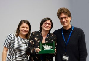 Rosa Paolicelli holds her trophy, a 3D printed microglia. Mariko Bennett and Cornelius Gross stand either side of her