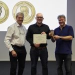 Chair of the Alumni Association Gareth Griffiths (left) and Director of EMBL-EBI Ewan Birney (right) present Nils Gehlenborg with the John Kendrew Award. PHOTO: Photolab /EMBL