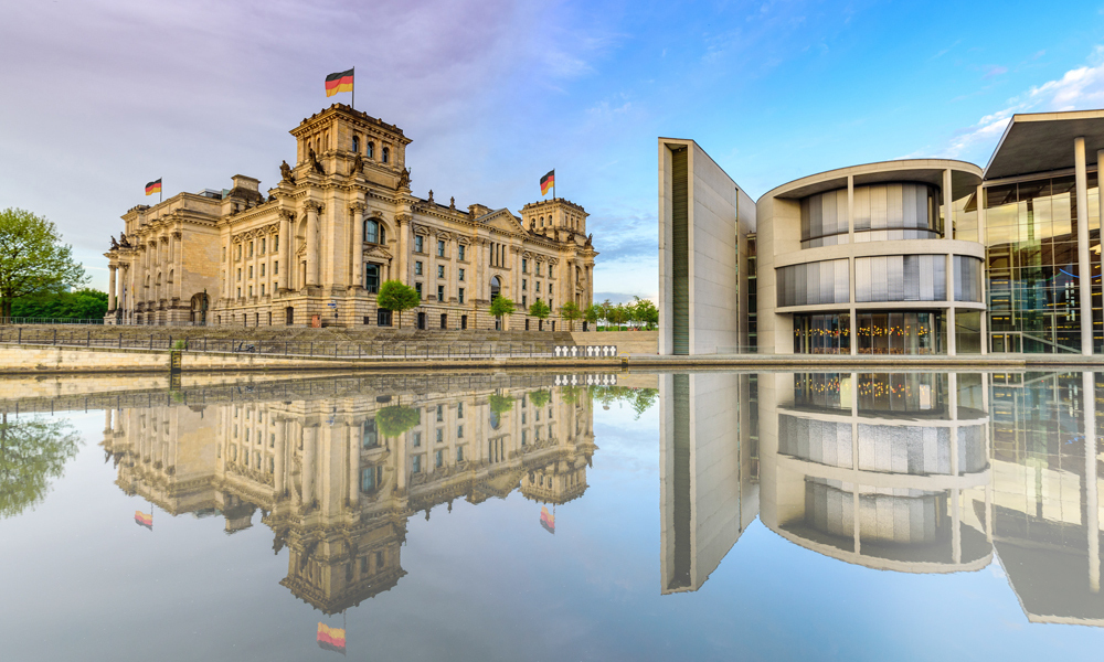 The Reichstag building (left) and Paul-Löbe-Haus (right) in Berlin, as seen in daylight from across the Spree river.