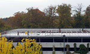 Car parking rooftop with a solar power plant under construction on it.