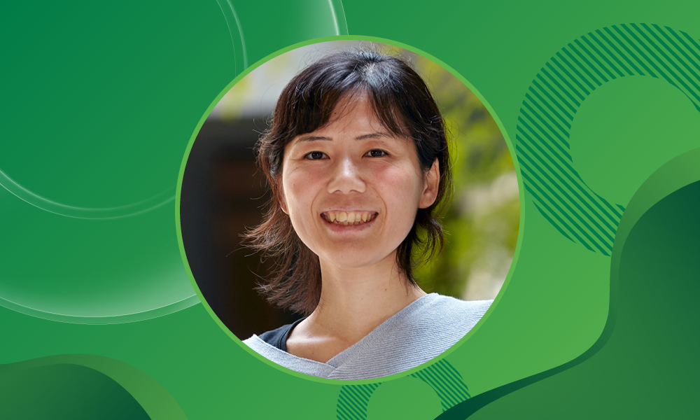 Portrait photo of EMBL group leader Miki Ebisuya against a green background.