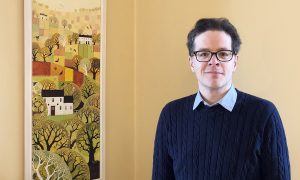 Man standing next to painting