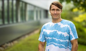 Man in white and blue t-shirt in outdoor setting