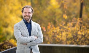 Male scientist in front of blurred woodland background