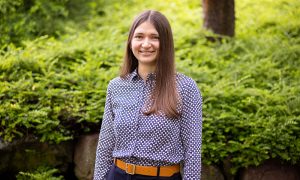 Female scientist in front of a background of green plants