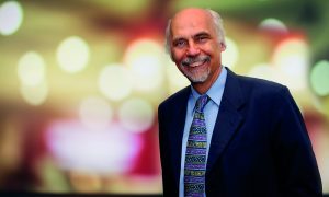 Male scientist stands in front of blurred background