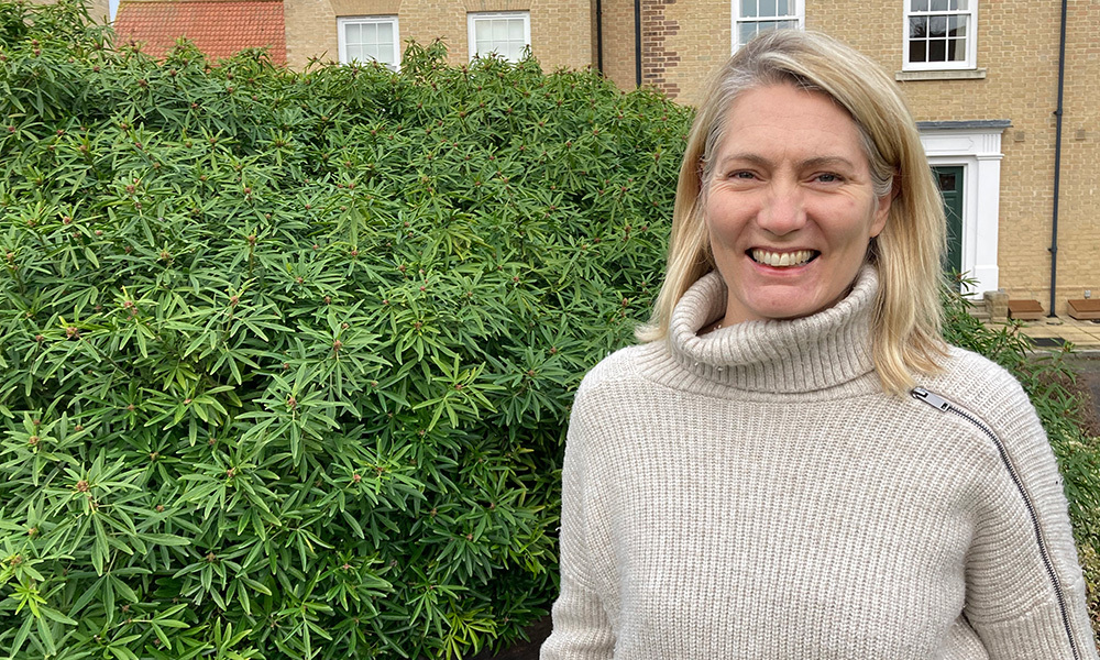 Woman standing next to a hedge