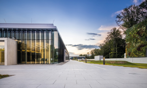 A building with glass facades and courtyard in front.