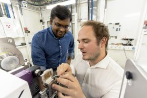 Two EMBL staff members looking at a piece of equipment