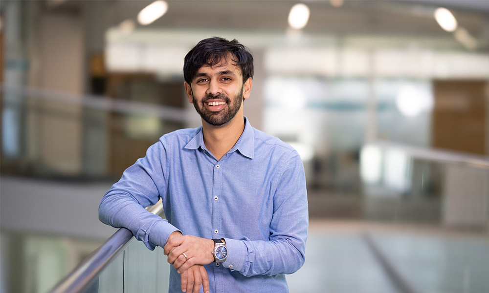 Male scientist looking towards the camera, against a blurred background