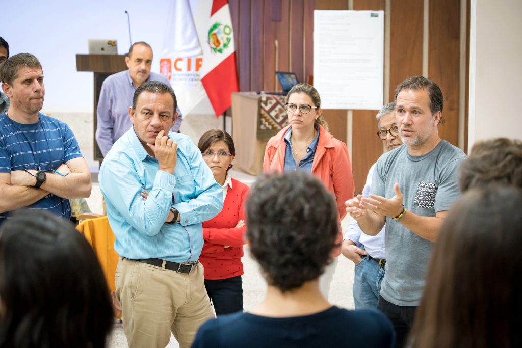 Group photograph of conference participants standing in a circle and discussing something.