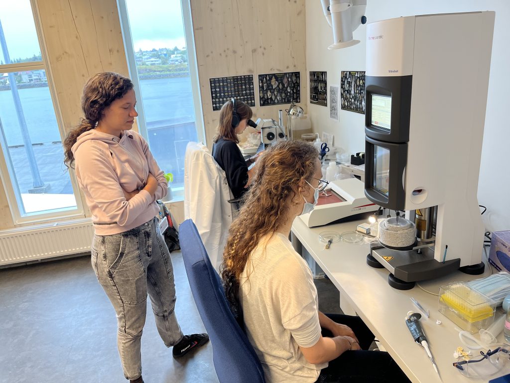 Three female scientists in a lab working on freezing samples.