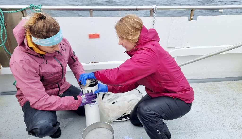 Two female scientists holding a filter for plankton. 