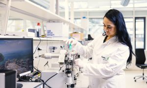 A photo of a scientist operating one of the instruments at the EMBL SPC Facility.