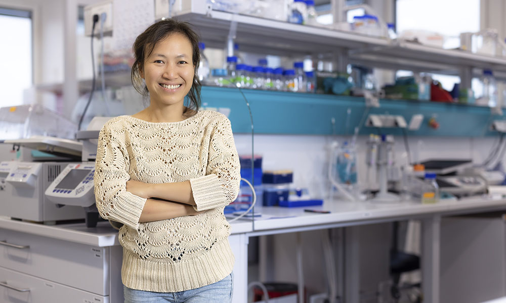 Female scientist stands in front of lab bench