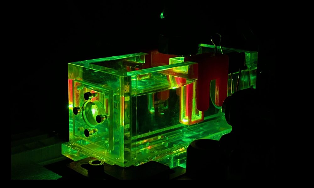Image showing the pulsed green laser exciting the photoacoustic signal of the sample in the cuvette.