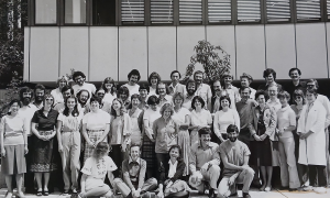 Black and white photograph showing a group of scientists standing in frnot of a building.