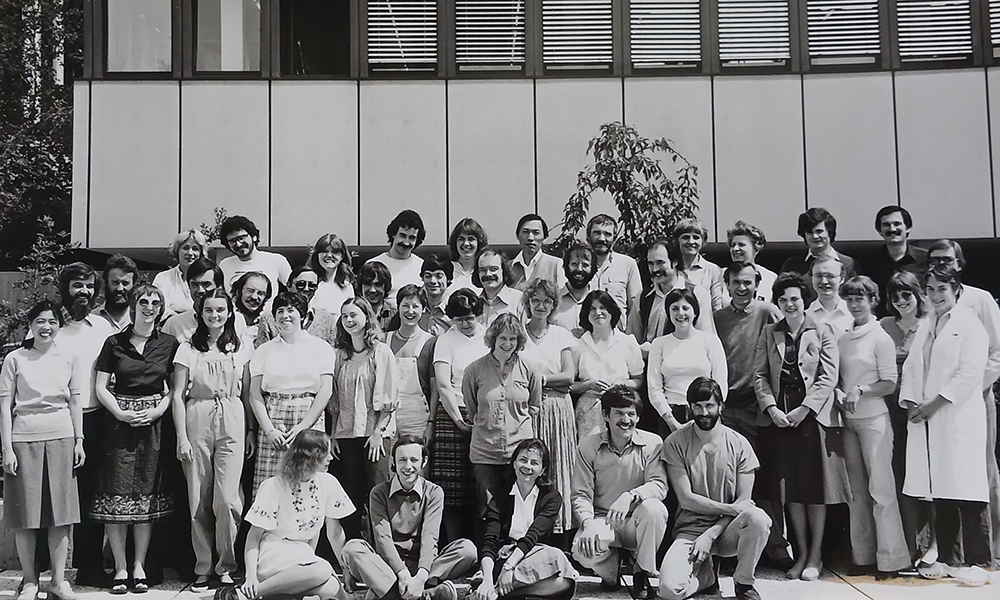 Black and white photograph showing a group of scientists standing in frnot of a building.