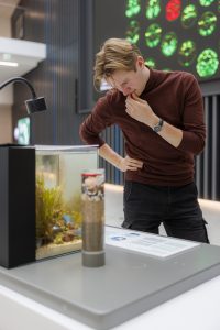 young male scientist reads exhibit display