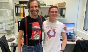 two male scientists look directly at the camera