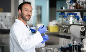Martin Pelosse, Scientific Expert at EMBL Grenoble. Man in white lab coat holding pipette and smiling in laboratory.