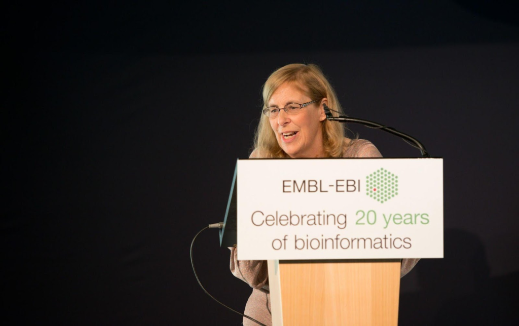 Female scientist giving a lecture from a podium.