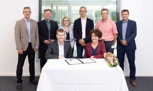 Michael Albiez (CEO, Carl Zeiss Microscopy) and Edith Heard (Director General EMBL) signing document about ZEISS-EMBL partnership