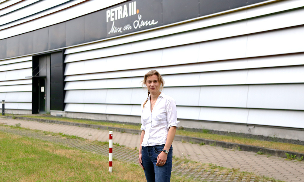 Photo of Selina Storm standing in front of the PETRA III synchrotron storage ring.