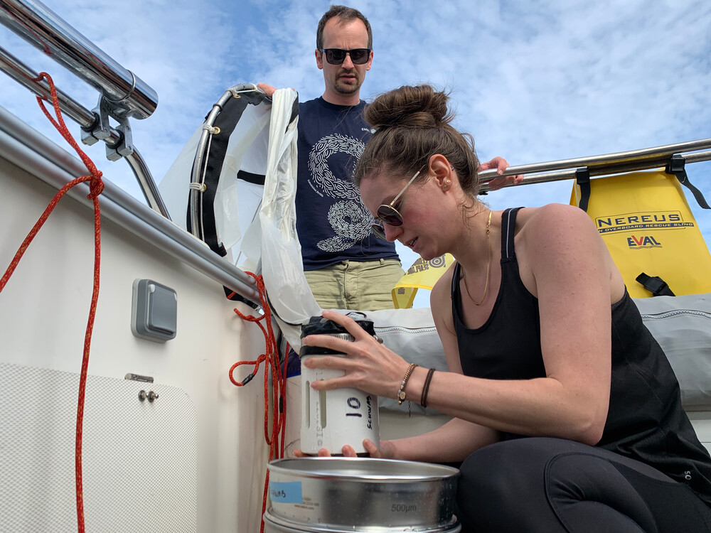 Two scientists photographed collecting samples. 