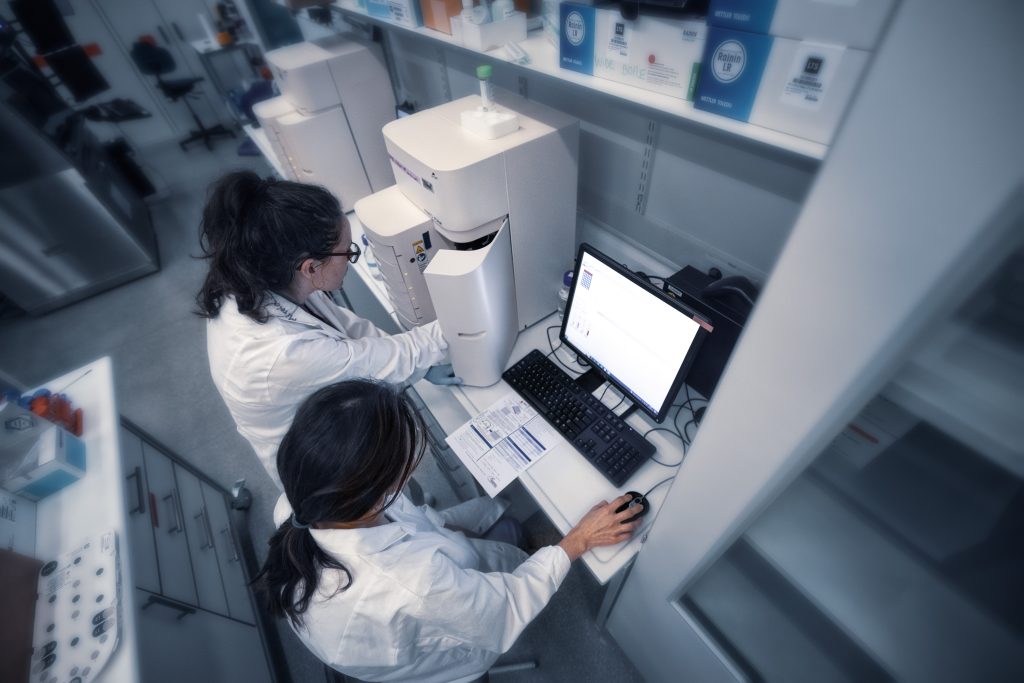 Two female scientists seen from above using a high-resolution electrophoresis Femto instrument