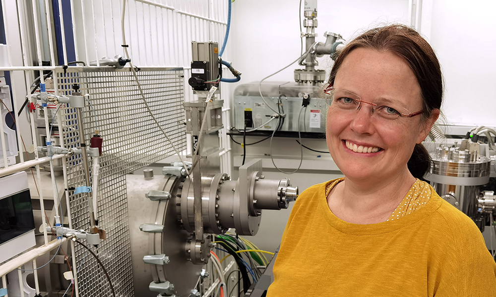 Female scientist stands in front of synchrotron