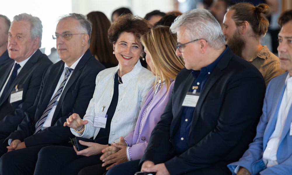 Heard sits among other guests during an event in Greece.