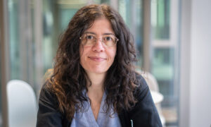 Close-up of smiling woman with glasses and long, dark, wavy hair. Person featured is called Aybuke Kupcu Yoldas. Photo credit: Jeff Dowling.