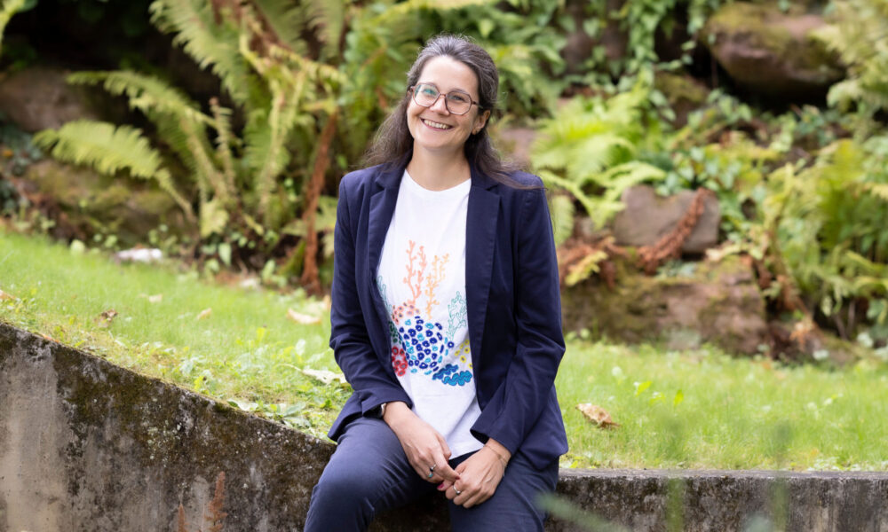 Smiling woman with glasses sitting outside