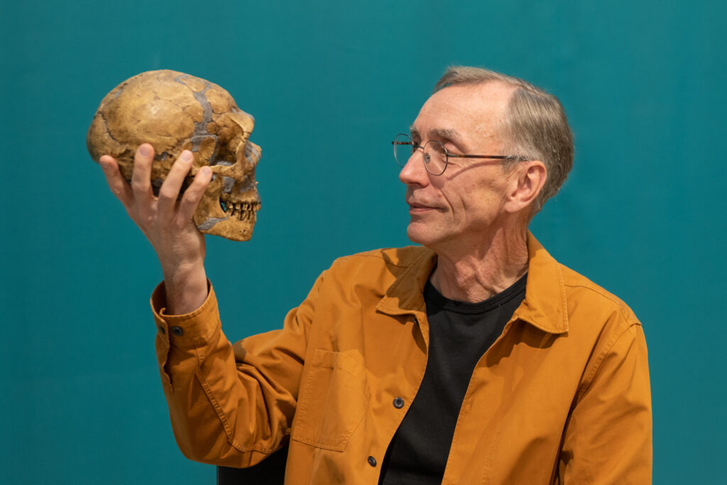 A man holding a Neanderthal skull