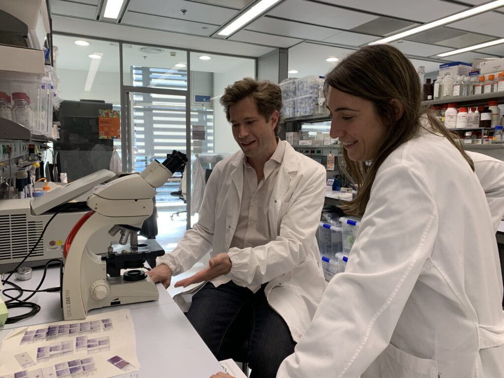 two scientists talking in front of microscope